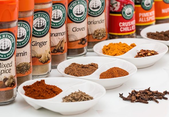 bermacam bumbu dapur dalam kemasan dijajarkan dan sampel bumbunya ada di depan di atas piring